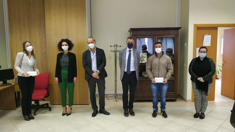 Gruppo di persone in un ufficio durante la premiazione delle borse di studio.
