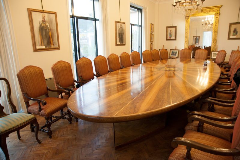 Sala riunioni con un lungo tavolo ovale e sedie disposte lungo i lati.