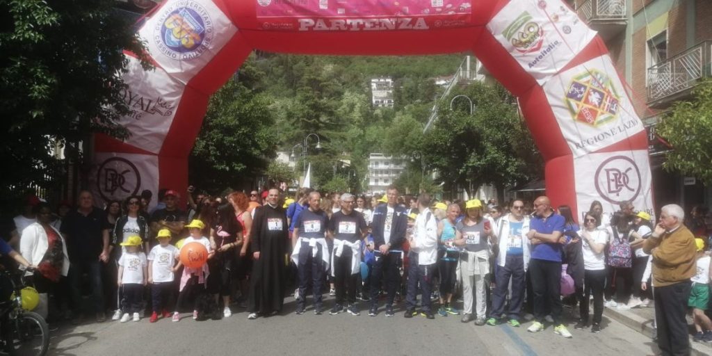 Gruppo di partecipanti alla partenza della maratona sotto un arco gonfiabile.
